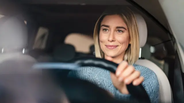 Image of woman in the drivers seat of a car looking confidently ahead