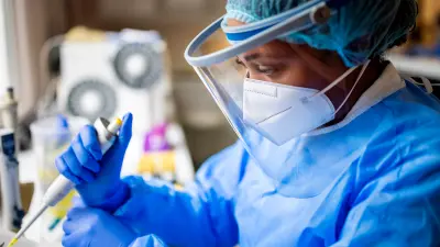 Image of MTA dressed in protective clothing, who is working in a medical lab
