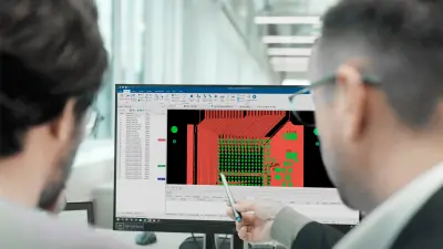Engineers reviewing PCB design on a computer screen, highlighting the use of DFM principles with copperdot for optimal design for manufacturing.