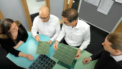 Team discussing PCB designs, exemplifying DFM principles at copperdot to enhance design for manufacturing processes.