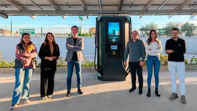Das Imecar-Team steht neben einer Ladestation für Elektrofahrzeuge und veranschaulicht seinen Erfolg mit Leiterplatten-Lösungen von copperdot.