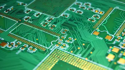 Close-up of a green printed circuit board (PCB) with fine conductor tracks and gold-colored contact surfaces.