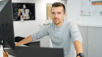 Ein junger, lächelnder Mitarbeiter von Bosch copperdot ist bereit, Bestellungen für flexible Leiterplatten in der Zentrale von Bosch copperdot entgegenzunehmen.