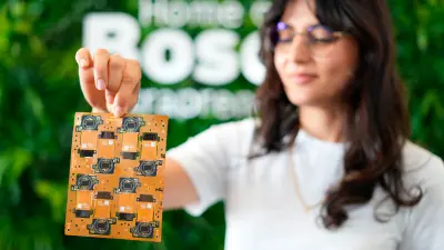 A woman holding a printed circuit board (PCB) with detailed designs, showcasing the advanced technology of copperdot.