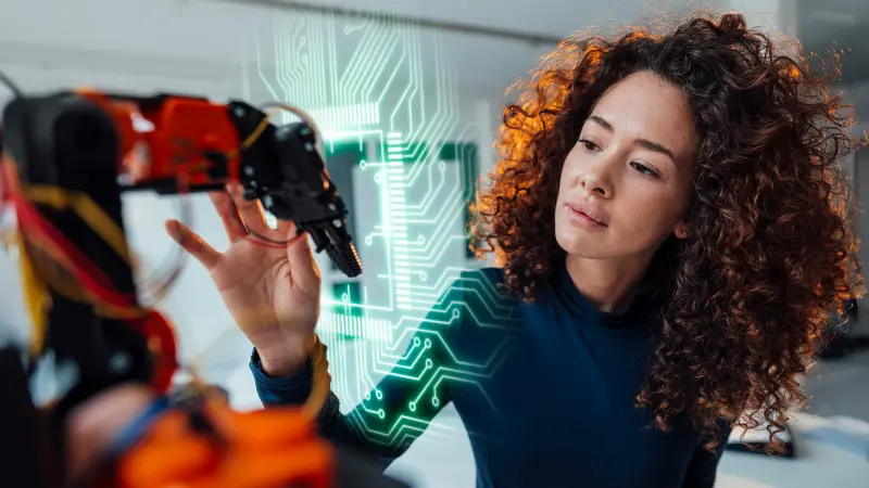 An engineer works on a robotic arm, enhanced by digital circuit traces – high-quality PCBs from copperdot enable precision and innovation in robotics.